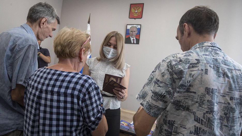 Russia issues passports for Ukrainians in Melitopol
epa10072574 A picture taken during a visit to Melitopol organized by the Russian military shows an official of a center for the preparation of documents for the registration of Russian citizenship and passport application, handing Russian passports to residents in Melitopol, Zaporizhia region, southeastern Ukraine, 14 July 2022 (issued 15 July 2022). On 11 June, several dozen Melitopol residents received their first passports as citizens of the Russian Federation. According to sources from the main council of the military-civilian administration of the Zaporizhia region, thousands of people in the region filed documents for obtaining Russian citizenship. Melitopol is under the control of Russian forces and the city is administered by a military-civilian administration. On 24 February 2022 Russian troops entered the Ukrainian territory in what the Russian president declared a 'Special Military Operation', starting an armed conflict that has provoked destruction and a humanitarian crisis.  EPA/SERGEI ILNITSKY 
Dostawca: PAP/EPA.
SERGEI ILNITSKY