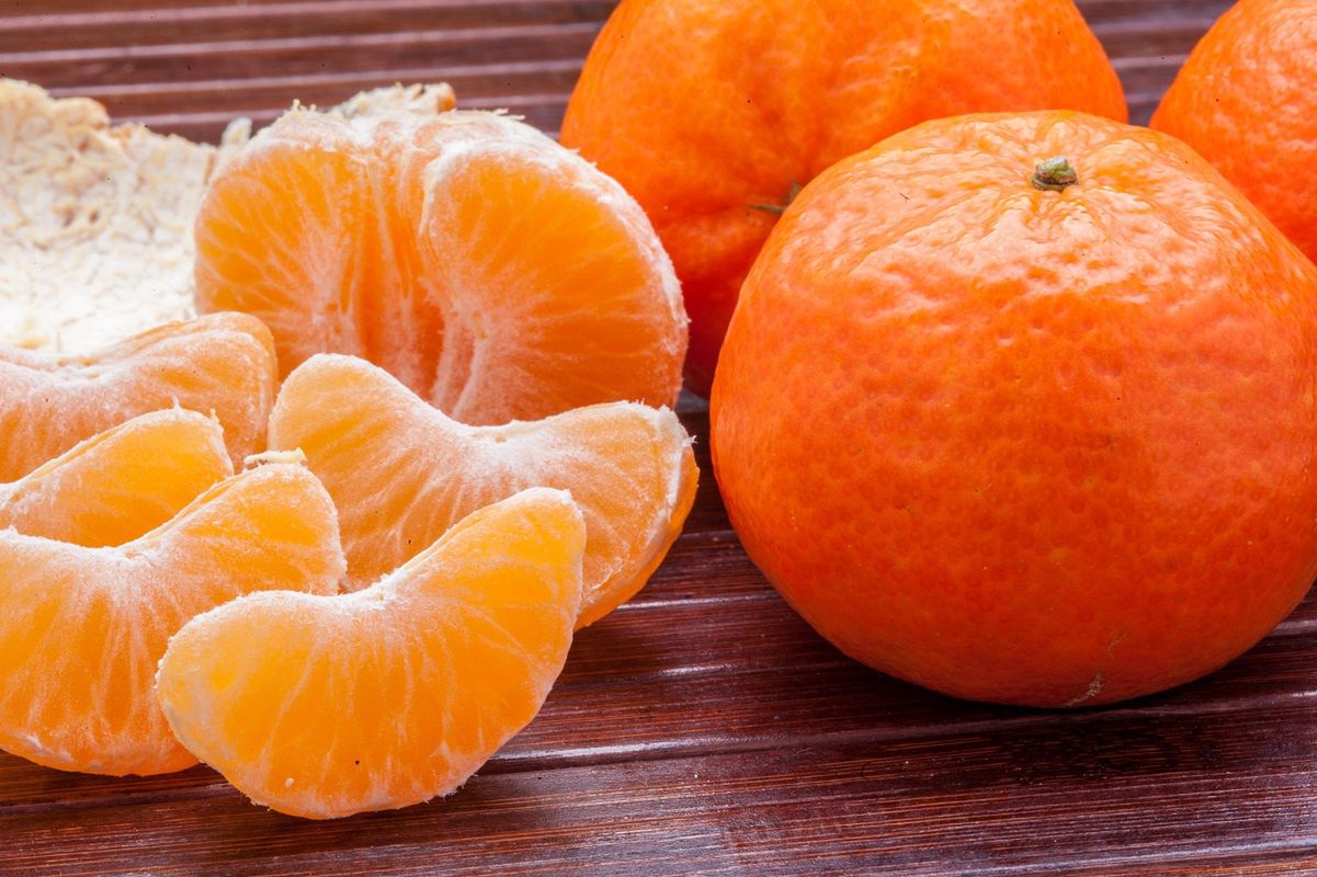 To clean tangerine. To remove a peel from tangerine. Cleaning of a madarin  of a peel. Stock Photo by ©vershinin.photo 188785458