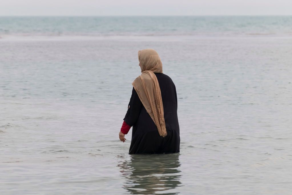 In a hijab on the beach