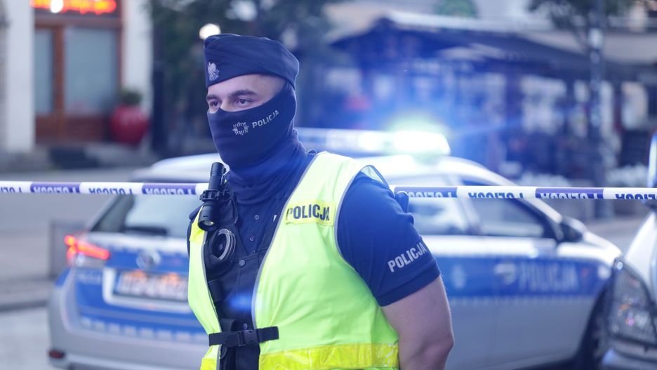 Policjant zabezpieczający ewakuowany teren Krakowskiego Przedmieścia w Warszawie