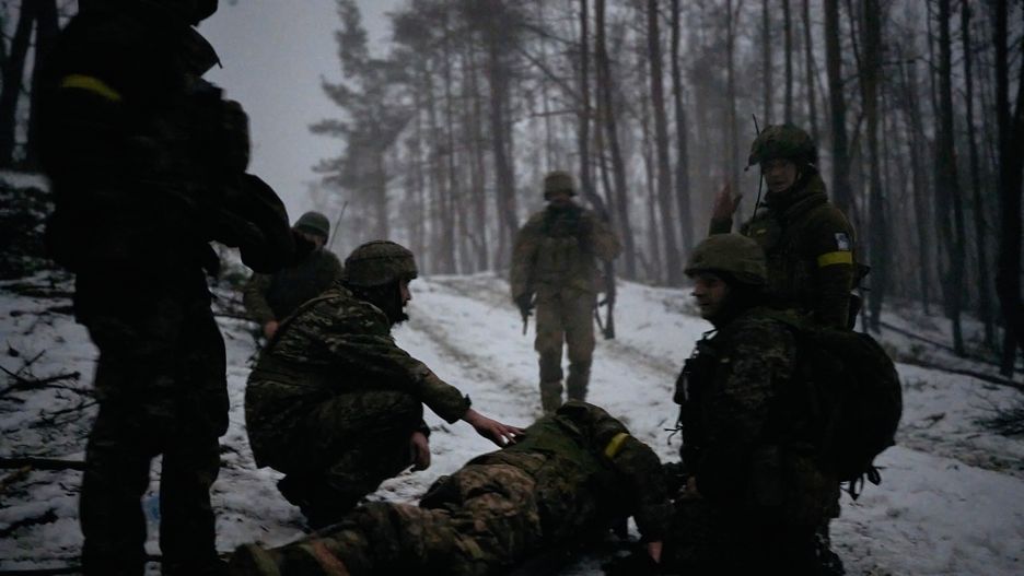 KUPIANSK FRONTLINE, UKRAINE - JANUARY 27: Medics evacuate a wounded soldier who tripped on a petal mine as evacuation takes place in darkness in the middle of a damaged forest on January 27, 2024 in Kupiansk Frontline, Ukraine. The Edelweiss Brigade (also spelled Edelveys), a specialized unit within the Ukrainian ground forces, is trying to fend off near-constant Russian attacks on Kupiansk, which is mere kilometers from the frontline. Ukrainian soldiers, mountain assault infantry, hold the front in the winter forest. (Photo by Kostiantyn Liberov/Libkos/Getty Images)