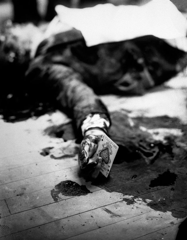 Ta scena pokazuje zdjęcia martwego bossa mafii - Joe Maserii, który leżał na podłodze brooklińskiej restauracji, trzymając w dłoniach asa pik. Ta karta jest znana jako symbol śmierci. Niezła ironia, co?