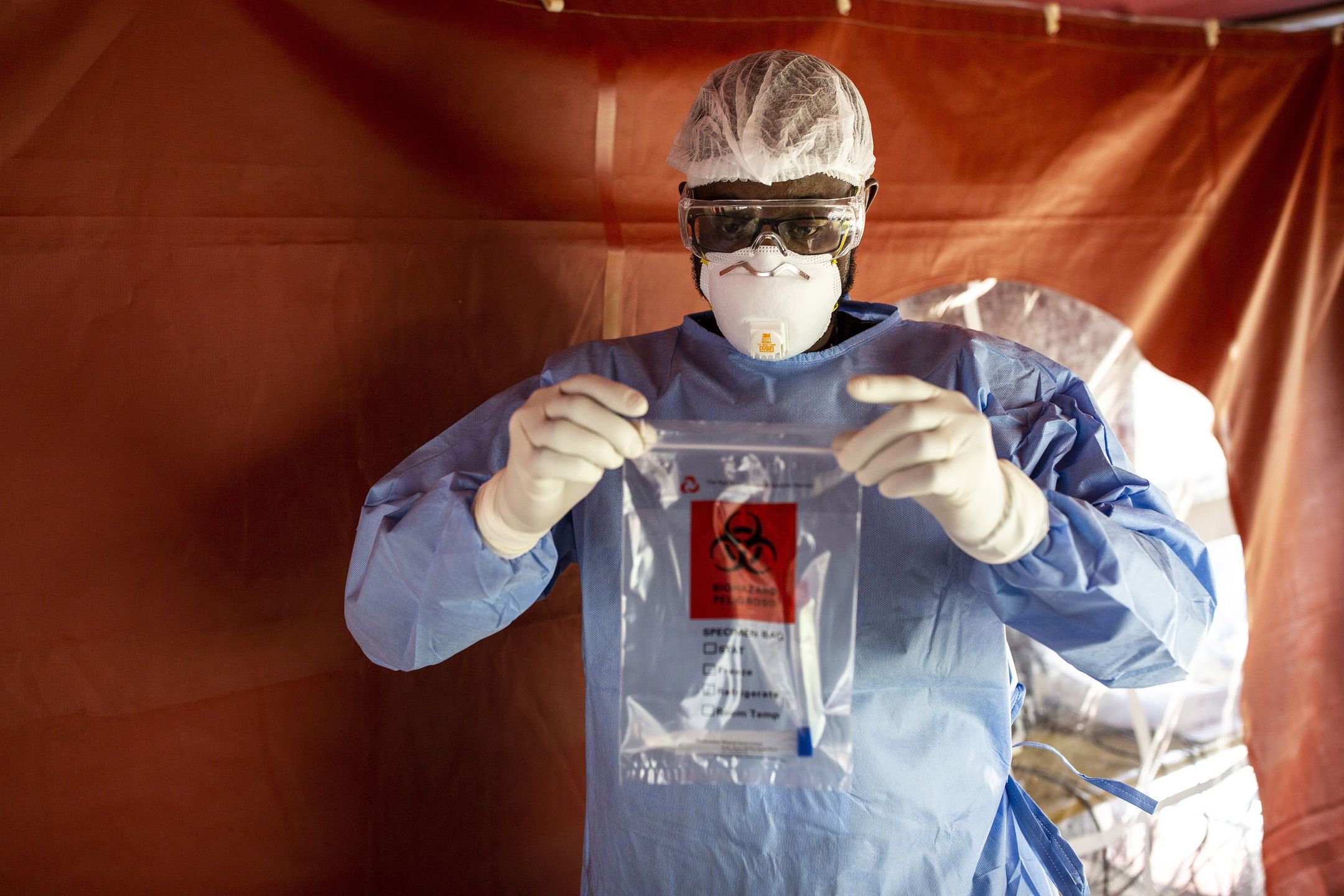 A doctor dressed in personal protective equipment (PPE) sealed a bag containing an oropharyngeal swab samples for Covid-19 testing at the Aga Khan University Hospital in Nairobi, Kenya, on Friday, April 24, 2020. The East African country enforced a curfew as part of measures to reduce the risk of contagion amid fears that Covid-19 patients will overrun its health system. Photographer: Patrick Meinhardt/Bloomberg via Getty Images