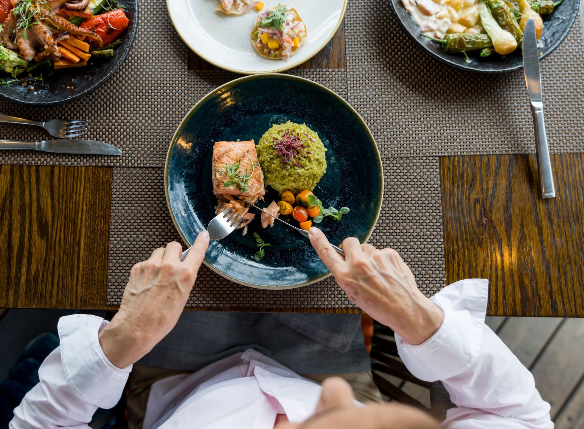 Close-up on a woman eating salmon for dinner at a restaurant
Close-up on a woman eating salmon for dinner at a restaurant - food and drink concepts
Hispanolistic
