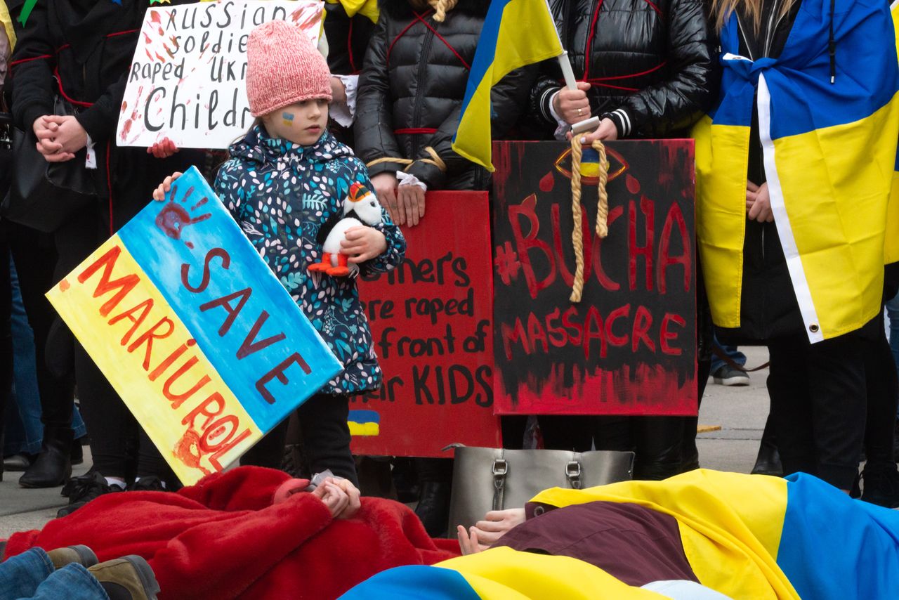 Protest w Toronto w Kanadzie: ludzie leżą na ziemi, odtwarzając ułożenie ciał Ukraińców zamordowanych przez Rosjan w Buczy i innych miastach 