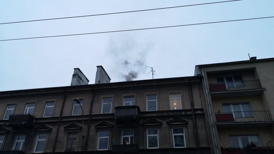 Czarny dym wydobywający się z komina kamienicy