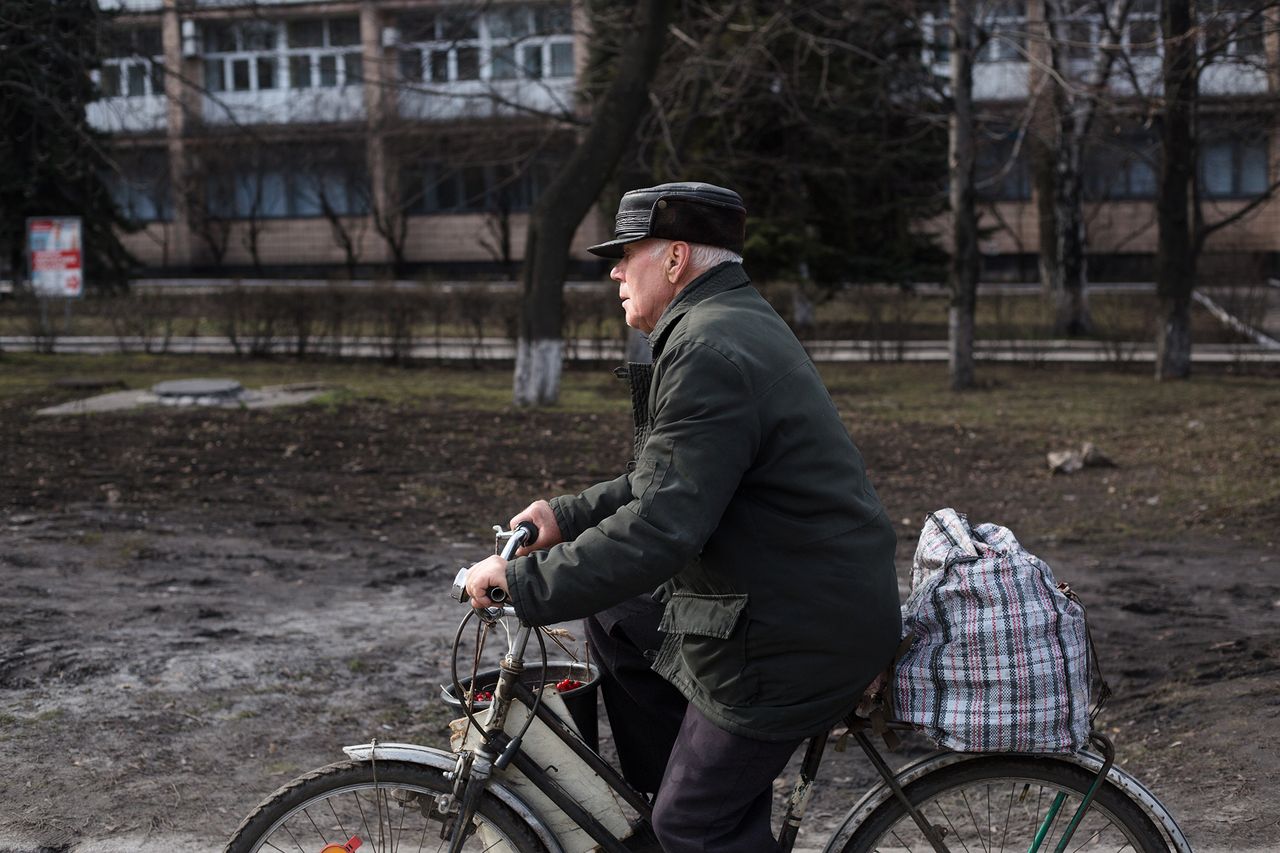 Mężczyzna z pakunkiem jadący przez Pokrowsk.