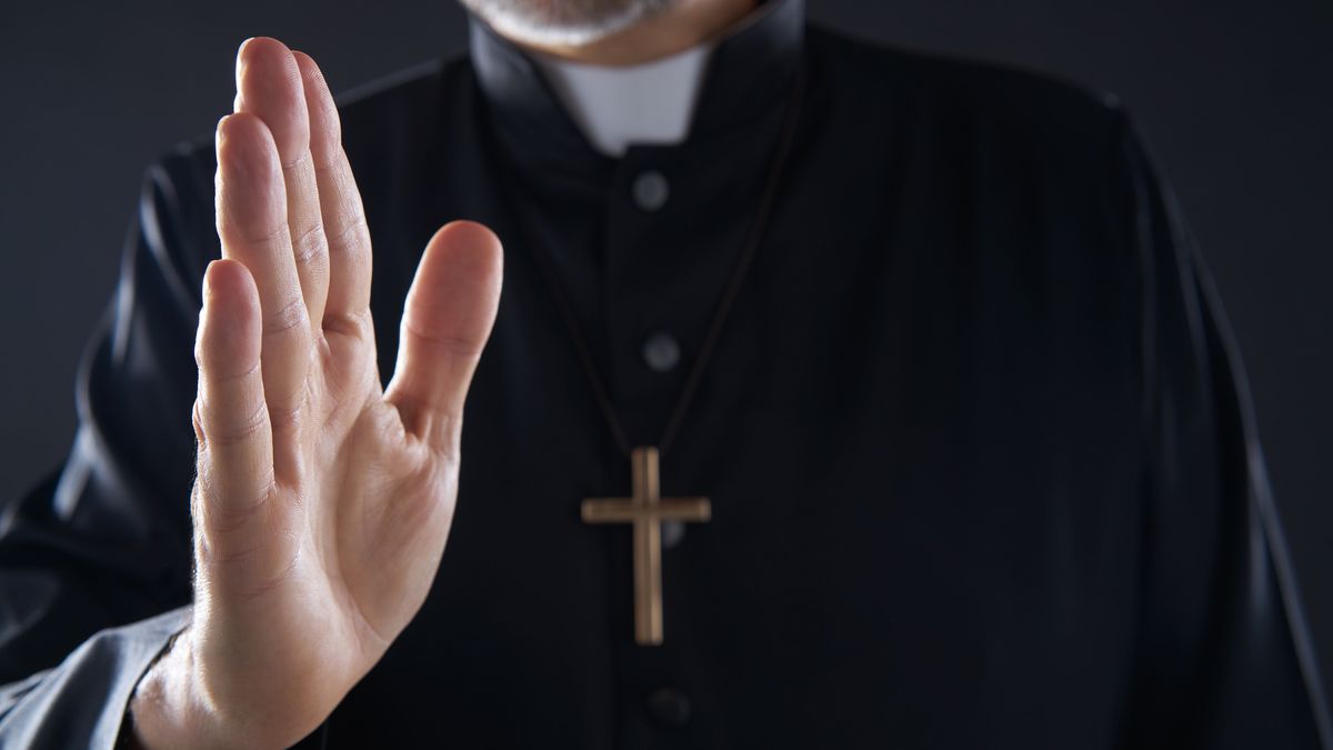 Pirest hand blessing closeup with cross

