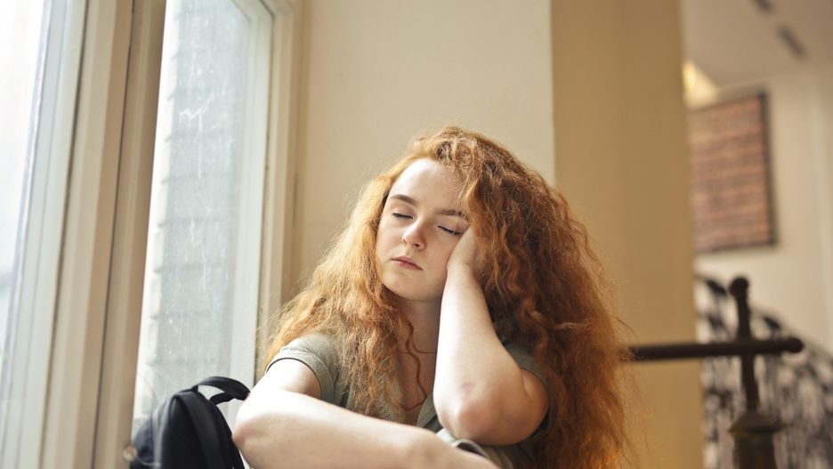 tired young woman in a school corridor