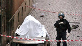 Włoski policjant obok spalonego samochodu