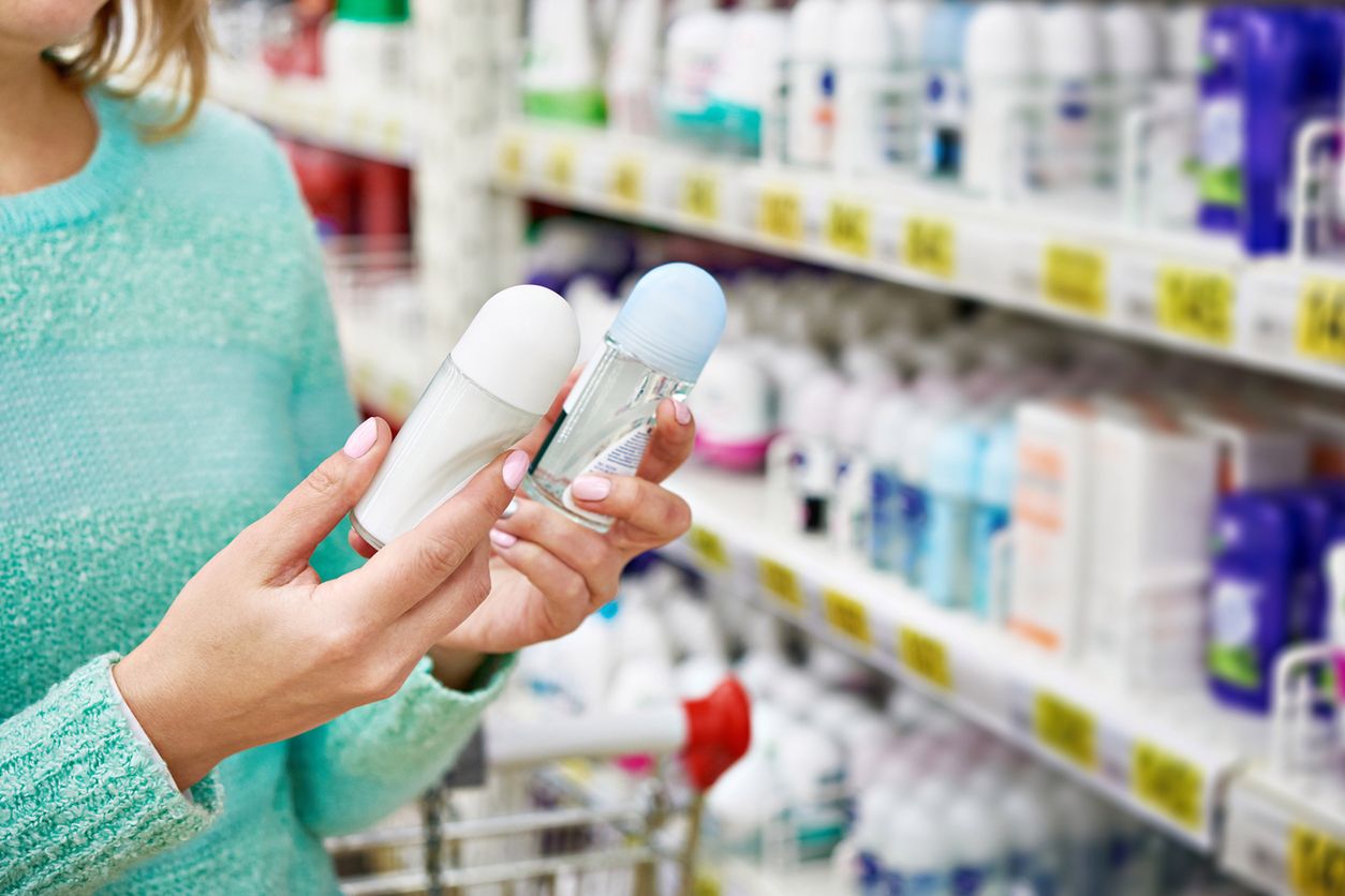 Woman in shop chooses deodorant closeup 