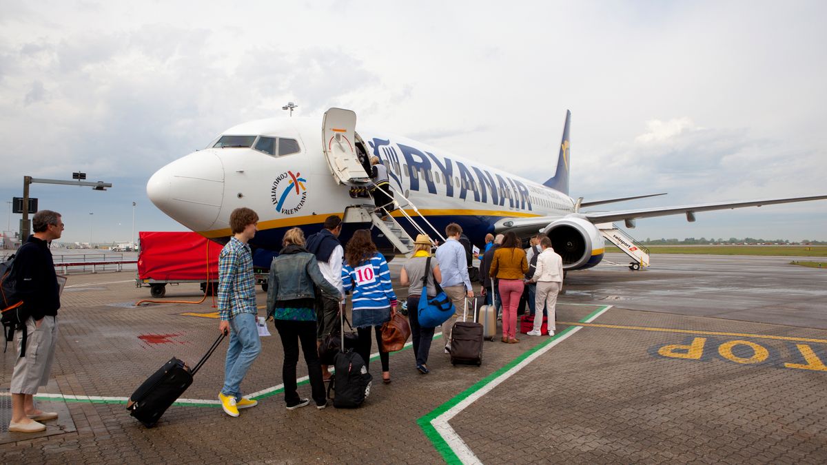 A queue of travelers on the tarmac preparing to board a Ryanair airplane at Stansted Airport in London.