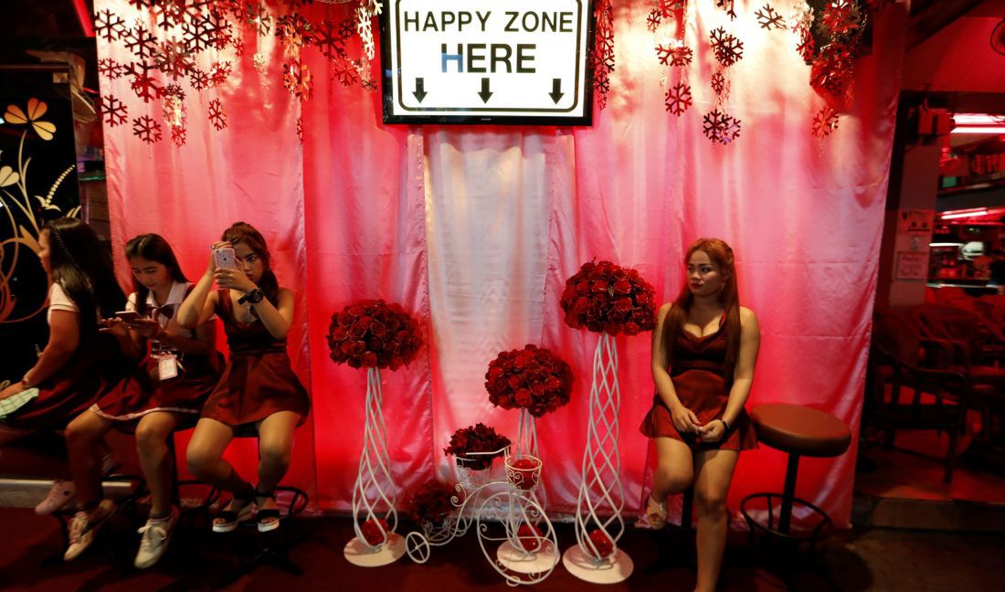 Kobiety siedzące na zewnątrz klubu go-go. Pattaya, marzec 2017 roku. 