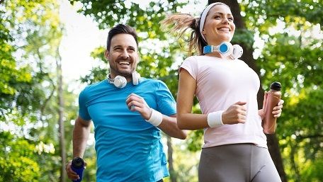 Couple jogging and running outdoors in nature, exercising together