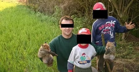 Z martwym lisem w ręku. Dumni myśliwi robią dzieciom zdjęcia