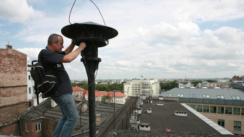 Konserwator sprawdza syrenę alarmową w Warszawie