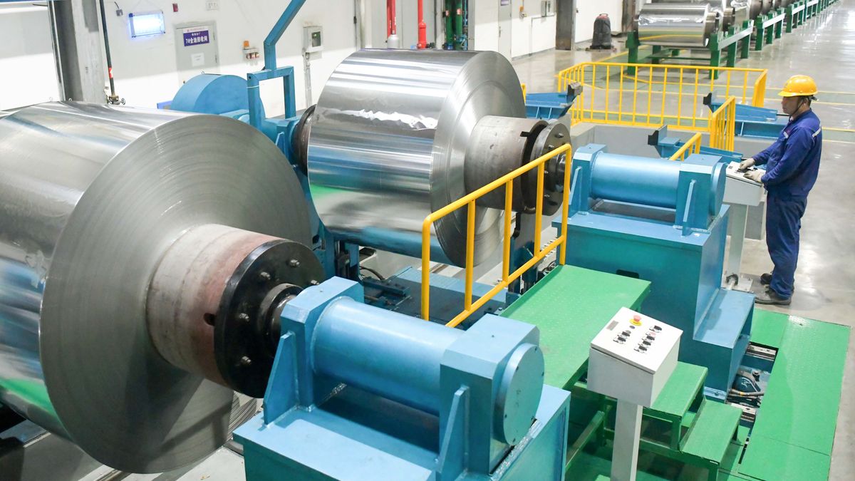 LUOYANG, CHINA - JULY 08: An employee manufactures aluminum foils for export at the workshop of Luoyang Longding Aluminum Industries Co., Ltd. on July 8, 2024 in Luoyang, Henan Province of China. (Photo by Zhang Yixi/VCG via Getty Images)