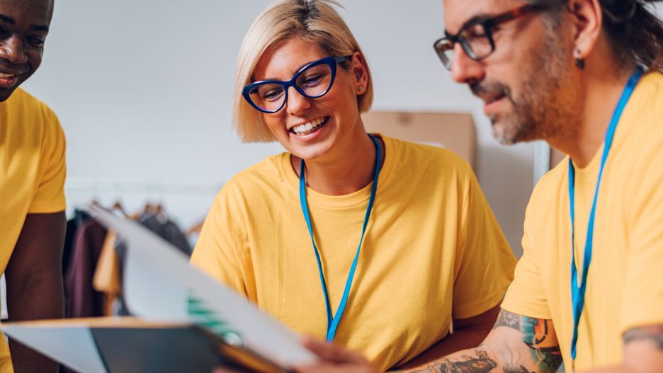 Group of multiracial volunteers working in community charity donation center. Diverse volunteers collecting food donations in a warehouse. Focus on a blonde caucasian woman wearing eyeglasses.volunteers, clipboard, checklist, smiling, man, woman, young, middle aged, team, working, charity, donations, copy space, multiracial, caucasian, african american, volunteer, organization, group, together, diversity, assistance, social worker, helping, cardboard box, donation, people, support, social, indoor, teamwork, help, adult, work, aid, community, food, togetherness, lifestyle, humanitarian, clothes, female, diverse, male, clothing, care, donate, grocery, packing, refugee, volunteers, clipboard, checklist, smiling, man, woman, young, middle aged, team, working, charity, donations, copy space, multiracial, caucasian, african american, volunteer, organization, group, together, diversity, assistance, social worker, helping, cardboard box, donation, people, support, social, indoor, teamwork, help, adult, work, aid, community, food, togetherness, lifestyle, humanitarian, clothes, female, diverse, male, clothing, care, donate, grocery, packing
