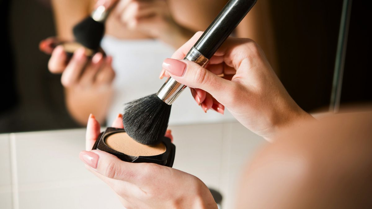 Kobieta nakłada puder pędzlem