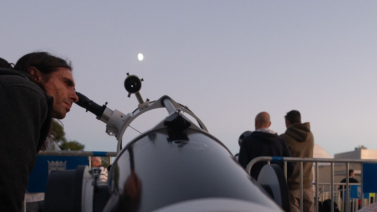 MADRID, SPAIN - 2024/09/13: A man looks to the moon through a telescope during an astronomical moon observation outside the planetarium. The Madrid Astronomical Association has made available to the public more than twenty telescopes for the observation of the moon and planets. (Photo by Marcos del Mazo/LightRocket via Getty Images)