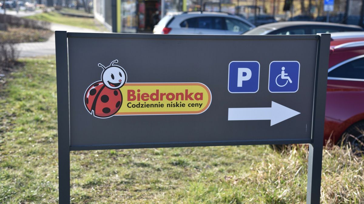 Wjazd na parking i logo dyskontu Biedronka.