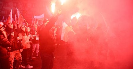 Zamaskowane osoby na Marszu Niepodległości. Słychać wybuchy, widać race