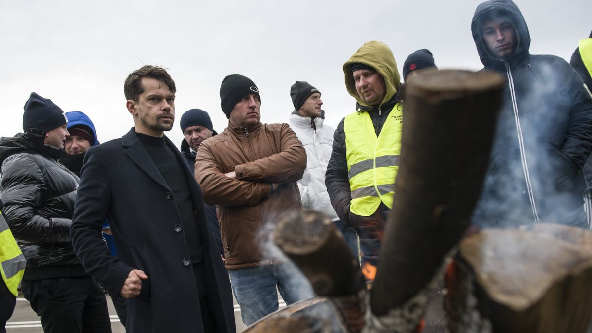 MEDYKA, POLAND - 2023/11/23: Michal Kolodziejczak, leader of the Agrounion and MP seen warming up with the farmers next to a brazier during the border blockade at the Medyka crossing. Polish farmers joined the hauliers' protest at the border crossing with Ukraine. Polish truckers have been protesting against the EU's liberalization of transport rules for Ukrainian trucks at three checkpoints since Nov. 6, causing huge lines on both sides of the border. Farmers from the "Betrayed Countryside" (Oszukana Wies) association plan to stage a three-day protest at the Polish-Ukrainian crossing at Medyka. This is the fourth polish border crossing where blockades were erected. 
According to EU rules, Ukrainian trucks do not require permits until June 30, 2024, after the EU and Ukraine signed an agreement in June 2022 to liberalize transport rules. Polish truckers claim that the lack of entry permits for Ukrainian trucks is hurting business for Polish hauliers. They also demand a ban on transport companies funded by entities outside the European Union. (Photo by Attila Husejnow/SOPA Images/LightRocket via Getty Images)