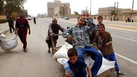 Irakijczycy, wyraźnie zadowoleni z siebie, transportują rzeczy, które wynieśli z budynków i biur w Bagdadzie (Fot. PAP/EPA)