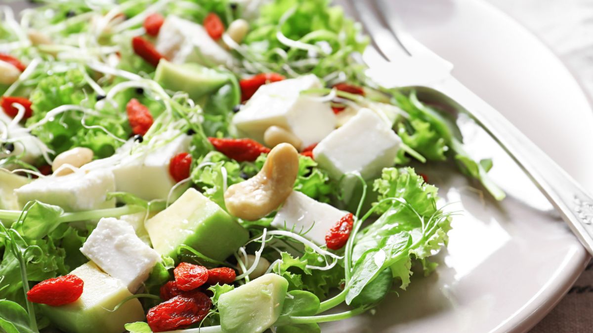 Sałatka z białym serem i awokado, posypana jagodami goji