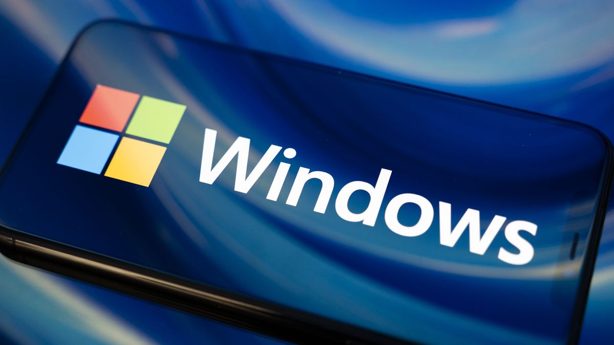 The Windows logo appears on the screen of a smartphone reflecting an abstract illustration in blue colors. Microsoft releases a major update to Windows 11 (25H2) and Windows 10 support ends permanently on October 14. In Creteil, France, on October 9, 2025. (Photo by Samuel Boivin/NurPhoto via Getty Images)
