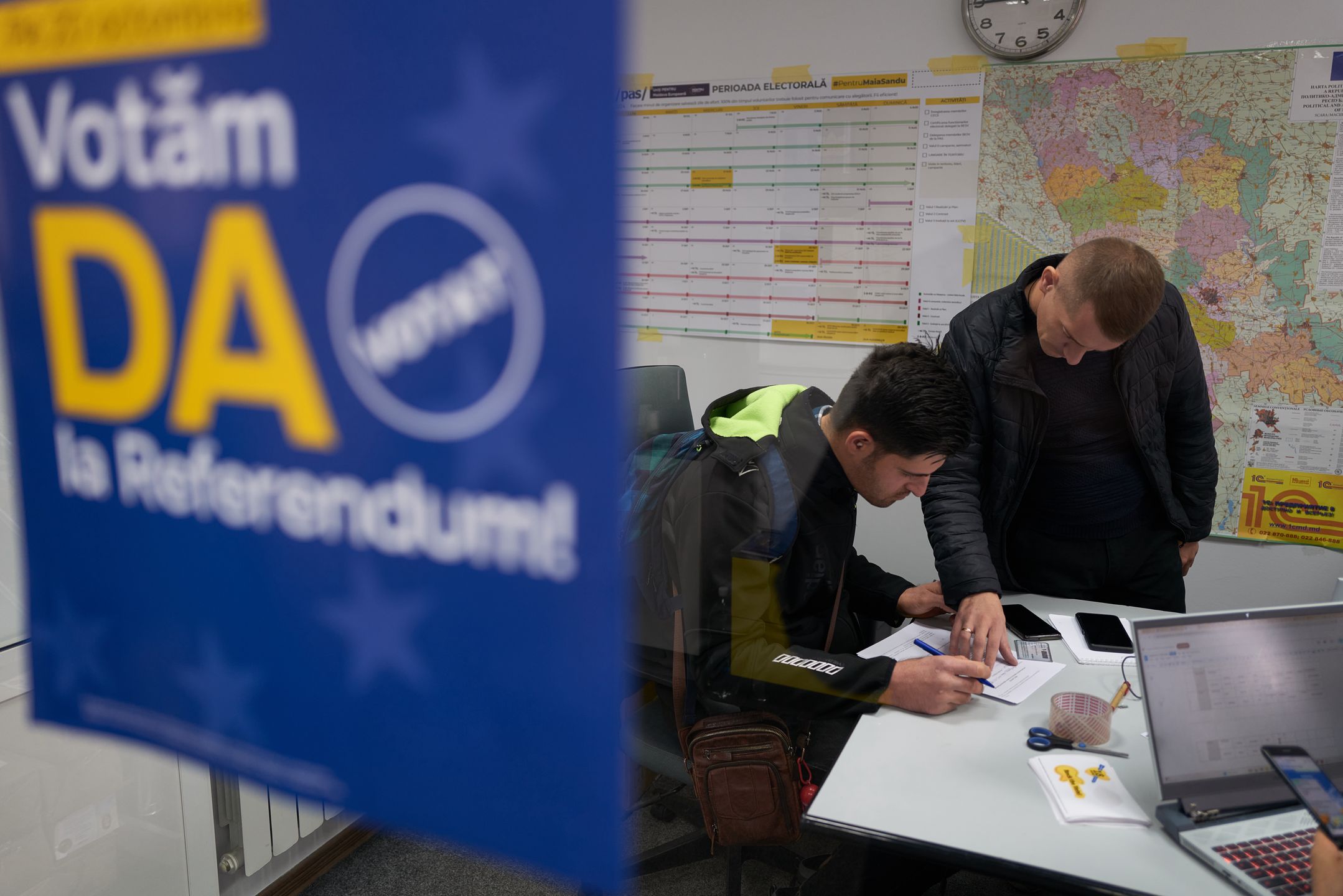 CHISINAU, MOLDOVA - OCTOBER 16: A supporter of the pro-European Union incumbent president, Maia Sandu, fills out paperwork at the Party of Action and Solidarity headquarters to make a legal donation of 2,000 lei, equivalent to approximately 100 euros on October 16, 2024 in Chisinau, Moldova. The poster urges voters to vote "Yes" in the European Union referendum. Earlier this month, police uncovered a $15 million vote-buying scheme allegedly funded by Russia, involving individuals linked to fugitive businessman Ilan Shor. Moldova will hold its presidential election on Sunday, with incumbent pro-EU President Maia Sandu facing former prosecutor Alexandr Stoianoglo, backed by the pro-Russian Socialist Party, and nine other candidates. Voters will also decide in a referendum whether to amend the constitution to make EU membership an official national goal. (Photo by Pierre Crom/Getty Images)