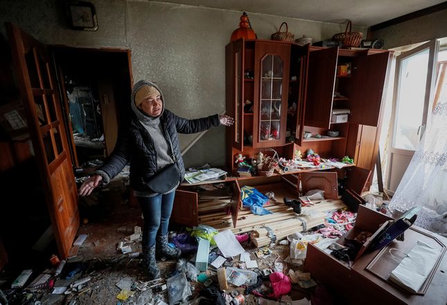 Olga pokazuje to, co zostało z jej mieszkania po ataku Rosjan.