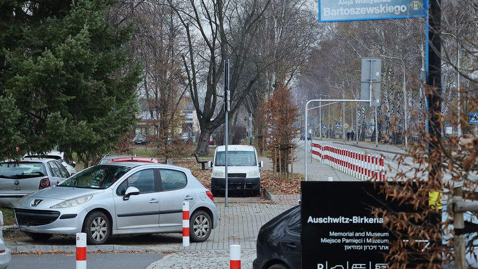 Samochody wszędzie stoją w pobliżu nowego centrum obsługi turystów Muzeum Auschwitz