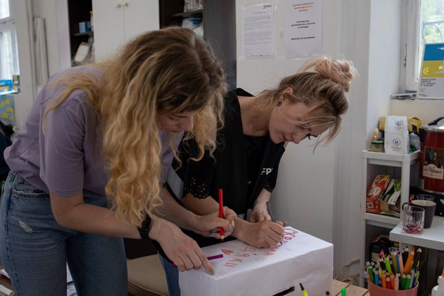 WARSAW, POLAND - 2022/05/12: Volunteers decorate a "thank you" box at the support centre for Ukrainian refugees. Front Pomocy Ukrainie (FPU), a charity group founded by Ukrainians residing in Poland, organize regular activities in their support centre to help Ukrainians integrate into the Polish community. (Photo by Hesther Ng/SOPA Images/LightRocket via Getty Images)