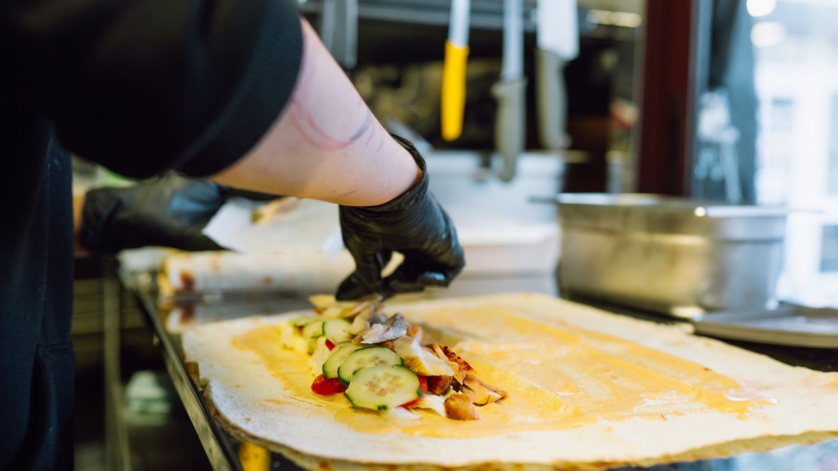 Chef preparing shawarma wrap with fresh ingredients at kitchen
Chef's hands in gloves preparing fresh shawarma or burrito with vegetables and eel fish
Olga Rolenko
