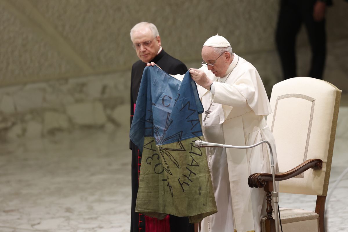 VATICAN, VATICAN CITY, APRIL 06:
Pope Francis holds an Ukrainian flag brought to him from Bucha, during his weekly general audience in the Paul VI hall at the Vatican City Vatican, on April 06, 2022. The Pope lamented the massacre of civilians in Bucha renewing his appeal for an end to the war in Ukraine. (Photo by Riccardo De Luca/Anadolu Agency via Getty Images)