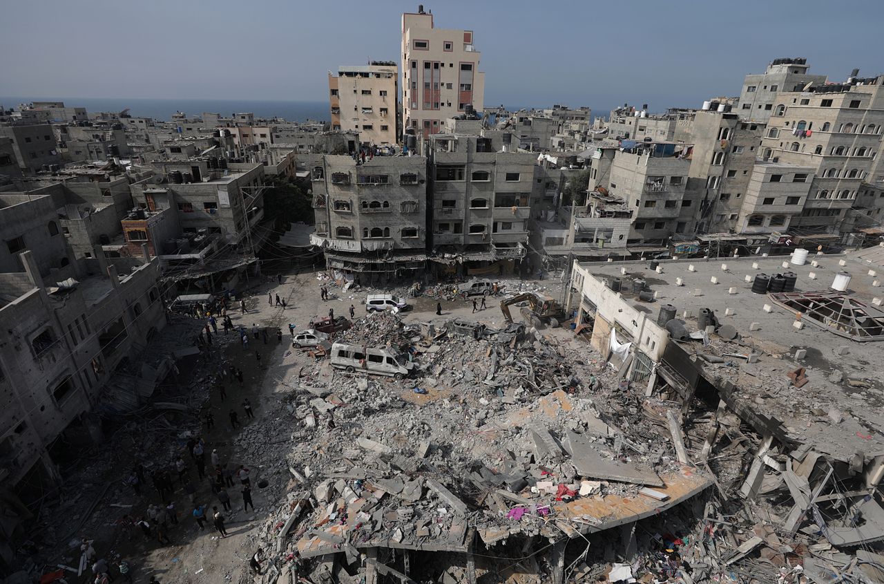 Palestinians search for bodies and survivors among the rubble of a destroyed building