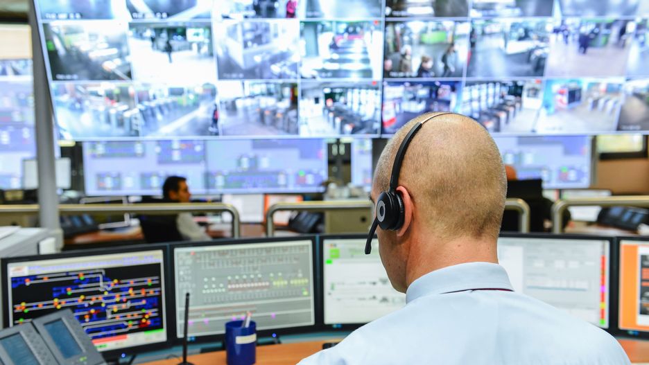 Człowiek przy ekranach monitoringu