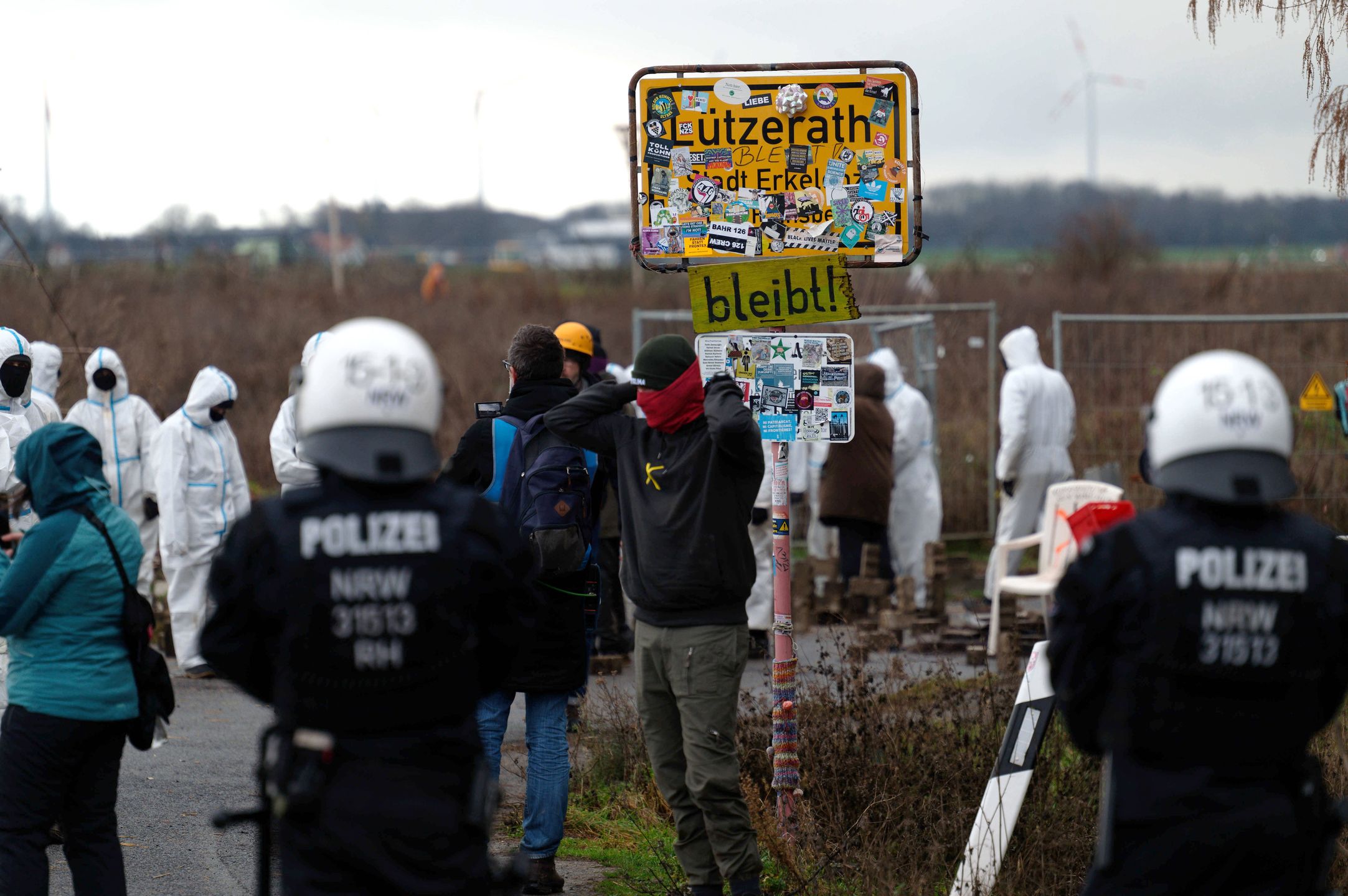 Activists block road to Luetzerath village set to be demolished
02 January 2023, North Rhine-Westphalia, Luetzerath: Police officers stand in front of activists on a road towards the village of Luetzerath. German climate activists positioned themselves on Monday behind a burning barricade to stop construction workers reaching a village earmarked for demolition for mining works. Photo: Henning Kaiser/dpa 
Dostawca: PAP/DPA.
Henning Kaiser