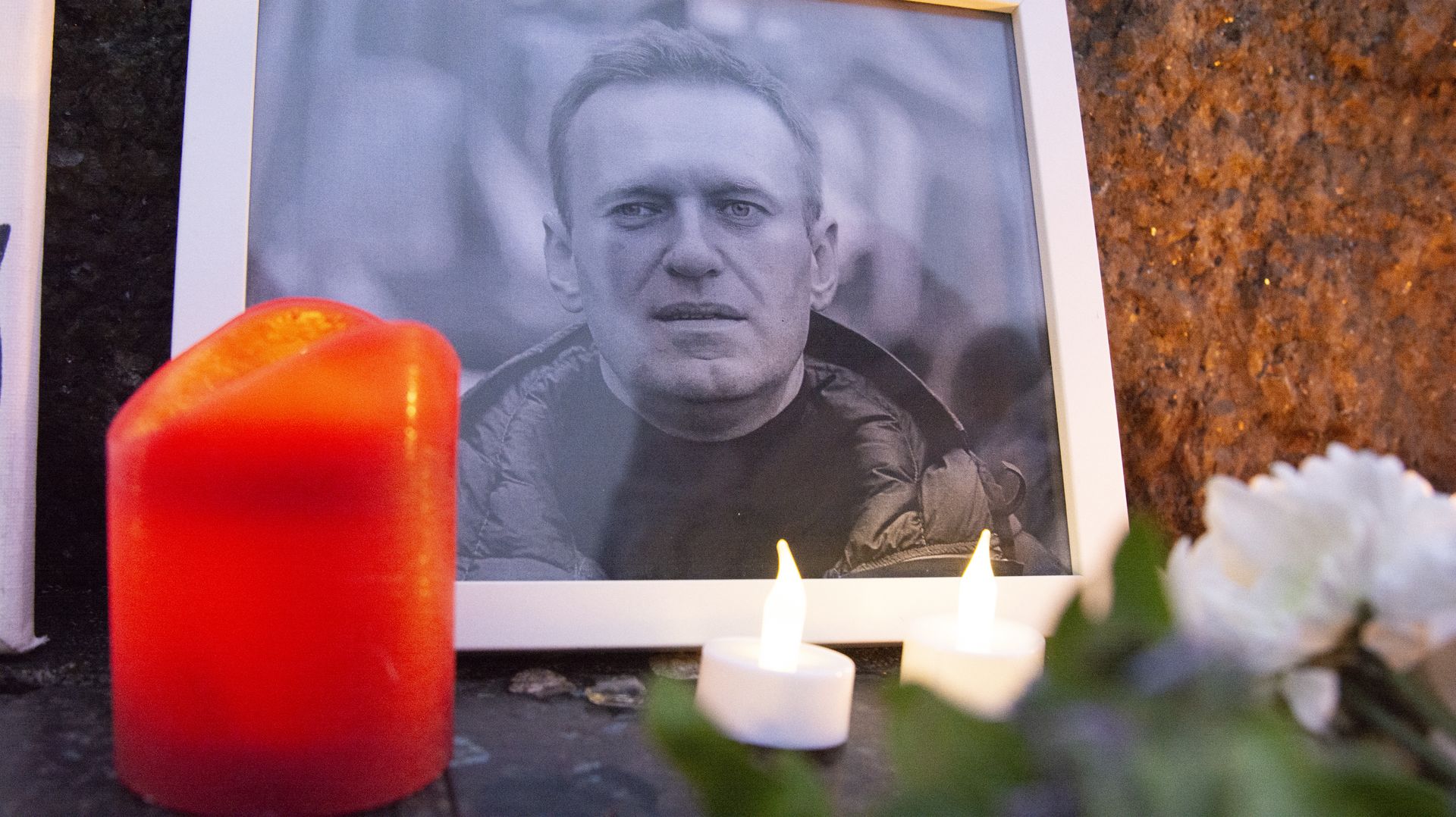 People are gathering and participating in a vigil to commemorate Alexei Navalny, with pictures, flowers, and candles visible at Roncalli Square in Cologne, Germany, on February 18, 2024. (Photo by Ying Tang/NurPhoto via Getty Images)