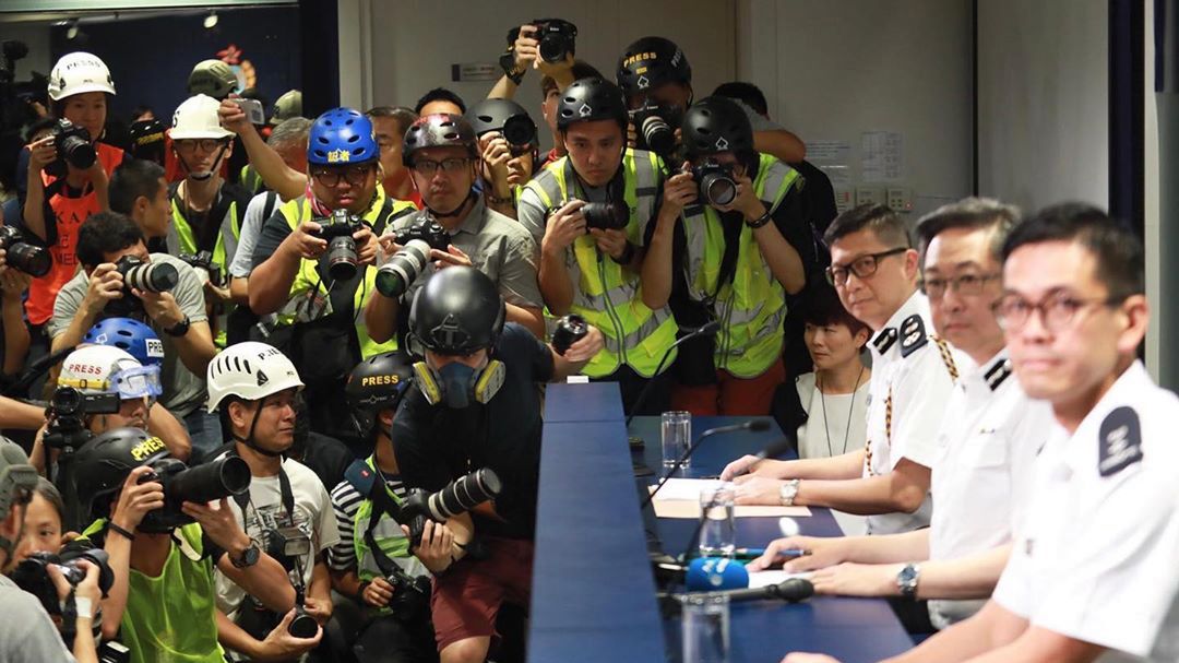 Fotoreporterzy w maskach i kamizelkach protestują przeciwko policji w Hongkongu 1