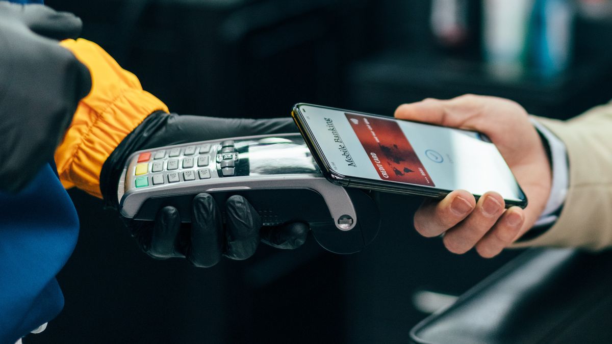 Businessman pay contactless with smartphone in the barber shop