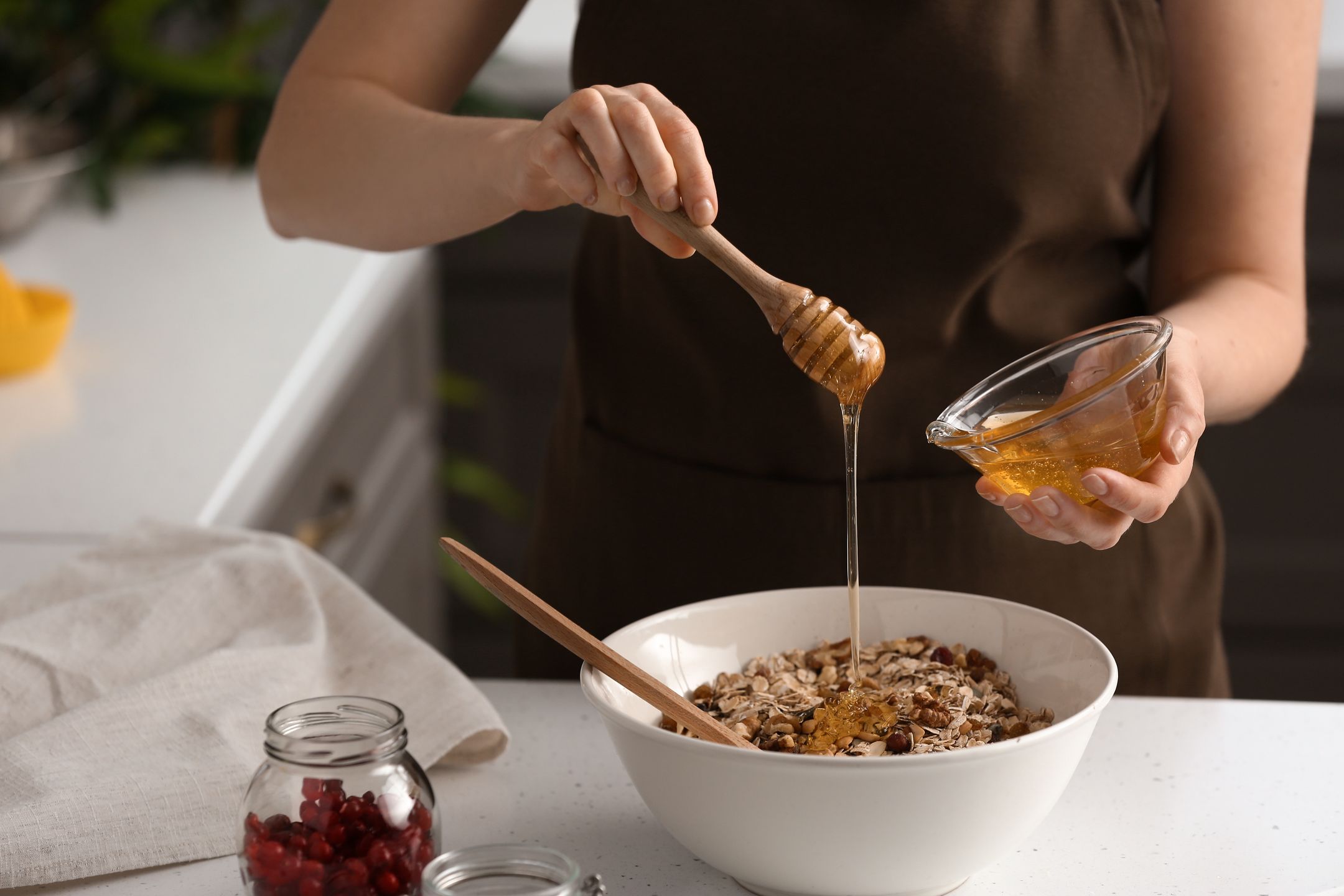 Woman making tasty granola bars in kitchenadding, bake, bars, benefits, berries, bowl, breakfast, cereal, cooking, crispy, crunchy, dessert, dietary, eat, energy, female, fit, food, fruits, grain, granola, hands, health, healthy, honey, ingredients, kitchen, making, mix, muesli, natural, nutrition, nuts, oats, people, person, preparing, protein, recipe, seeds, snack, sport, superfood, sweet, table, tasty, vegan, vegetarian, woman, young, adding, bake, bars, benefits, berries, bowl, breakfast, cereal, cooking, crispy, crunchy, dessert, dietary, eat, energy, female, fit, food, fruits, grain, granola, hands, health, healthy, honey, ingredients, kitchen, making, mix, muesli, natural, nutrition, nuts, oats, people, person, preparing, protein, recipe, seeds, snack, sport, superfood, sweet, table, tasty, vegan, vegetarian, woman, young