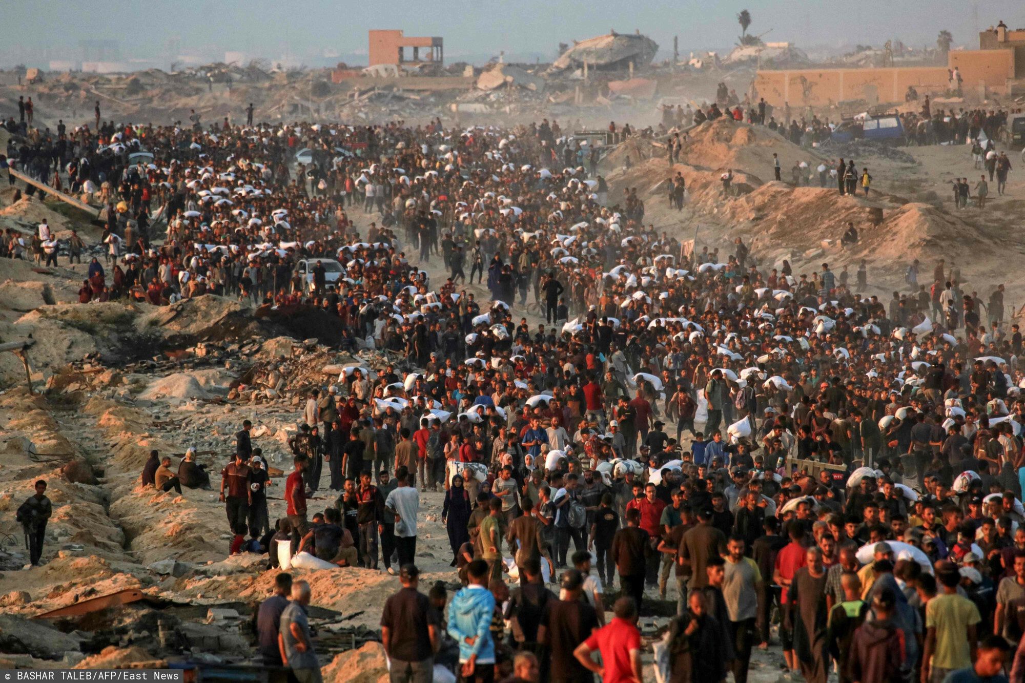 Archiwum zagraniczne East News 2025-06People carrying sacks of flour walk along al-Rashid street in western Jabalia on June 17, 2025, after humanitarian aid trucks reportedly entered the northern Gaza Strip through the Israeli-controlled Zikim border crossing, amid the ongoing war between Israel and Hamas. (Photo by BASHAR TALEB / AFP)BASHAR TALEB