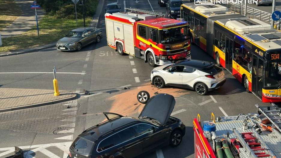Wielki wypadek drogowy z udziałem dwóch samochodów osobowych i wozu strażackiego na skrzyżowaniu ulic.