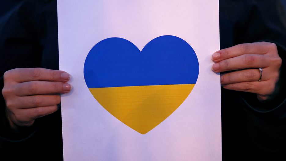 epa09781985 A Romanian civil rights activist woman holds a printed heart in Ukraine national colors to express her solidarity for Ukrainian people, outside the Embassy of the Ukraine in Bucharest, Romania, 24 February 2022. Russian troops launched a major military operation on Ukraine on 24 February, after weeks of intense diplomacy and the imposition of Western sanctions on Russia aimed at preventing an armed conflict in Ukraine.  EPA/ROBERT GHEMENT Dostawca: PAP/EPA.