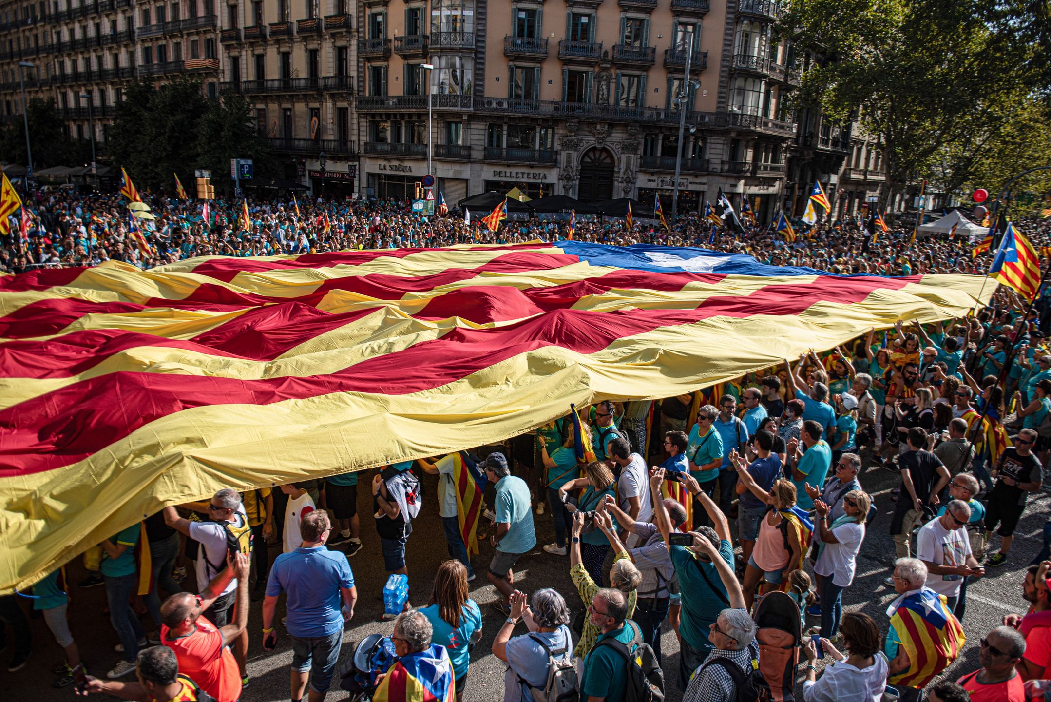 BARCELONA, CATALONIA, SPAIN - 2019/09/11: Protesters hold a large independence flag through the demonstration on the National Day of Catalonia, which has been organized by the Catalan National Assembly. (Photo by Xavi Ariza/SOPA Images/LightRocket via Getty Images)