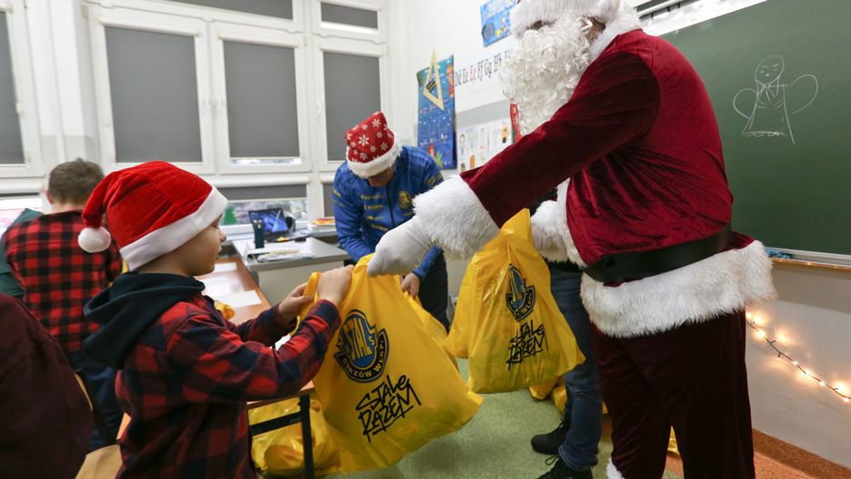 Gorzów Wielkopolski, 06.12.2023. Spotkanie uczniów Szkoły Podstawowej nr 10 z Mikołajem Stali Górzów, 6 bm. w Gorzowie Wielkopolskim. Prezenty dzieciom rozdawali żużlowiec, piłkarz ręczny i trenerzy Stali. (gj) PAP/Lech Muszyński