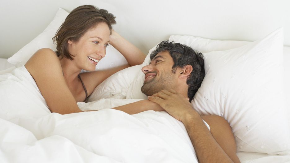Woman and man lying down in bed