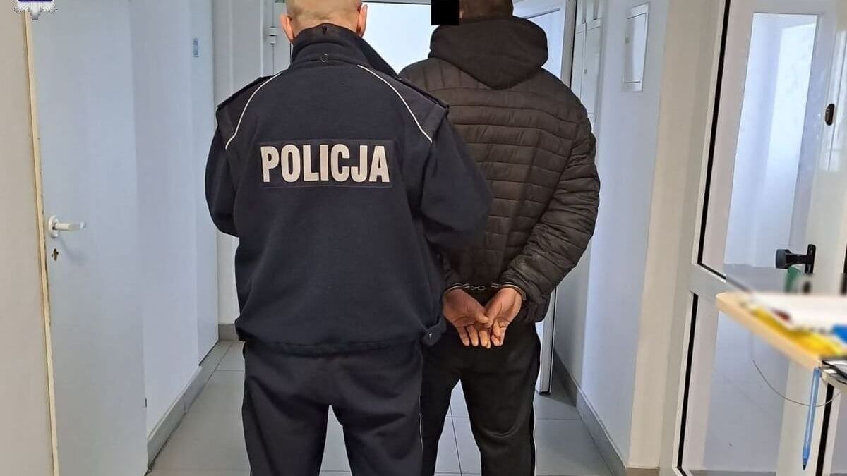 policjant prowadzi zatrzymanego mężczyznę